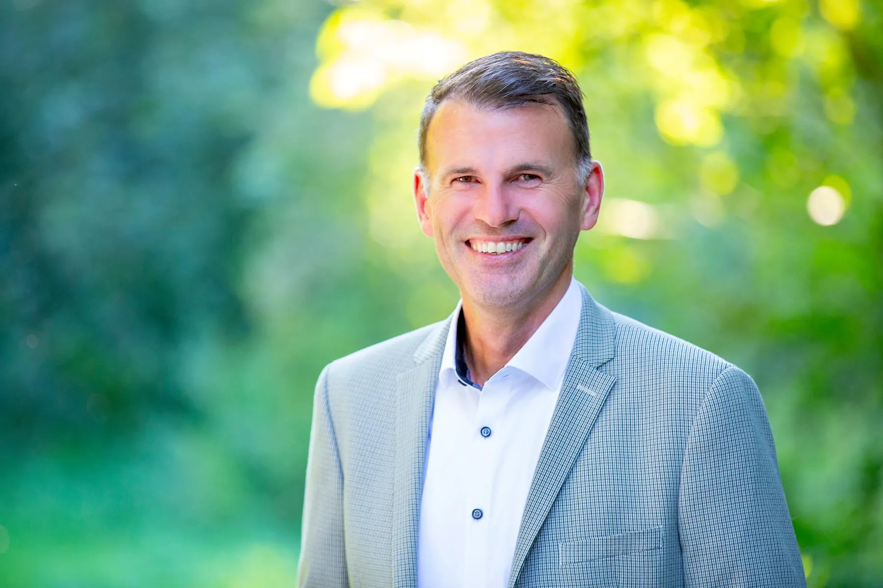 Bernd Stapfner im hellen Sakko auf einem Weg im Grünen